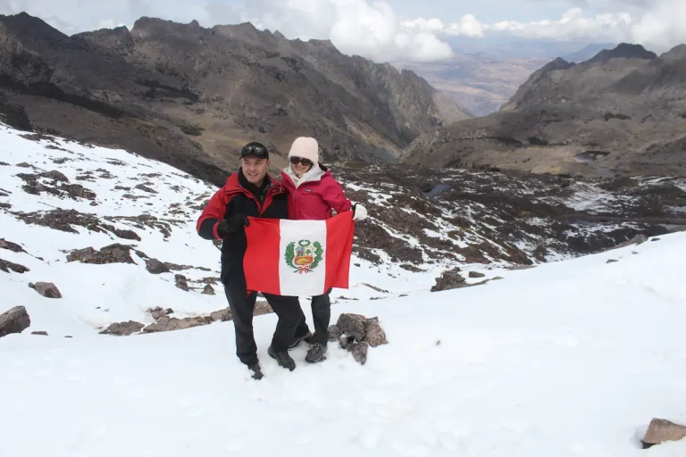 Travelers near a snowy mountain on the Lares Trek
